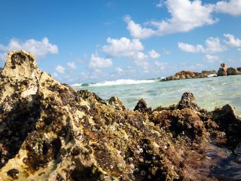 Rock formation on beach against sky