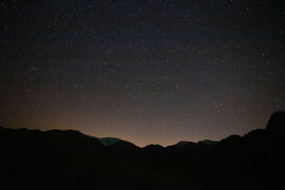 Scenic view of silhouette mountains against sky at night