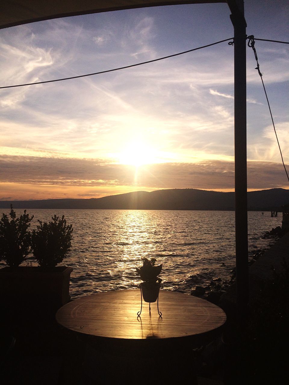 SILHOUETTE MAN ON SEA AGAINST ORANGE SKY