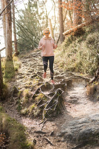 Woman standing by stream in forest