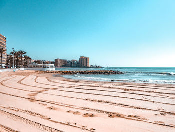 View of beach against clear blue sky