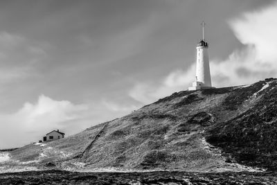 Lighthouse by sea against sky
