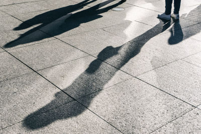 Low section of person standing on footpath in city