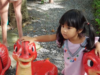 High angle view of cute girl standing by toy in park