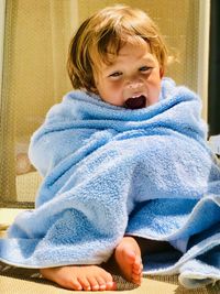 Smiling boy wrapped in blue towel