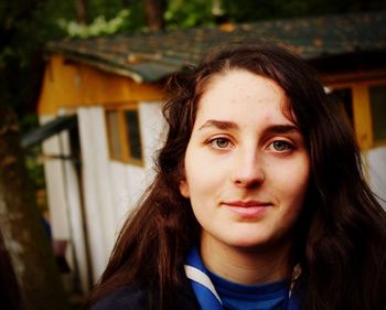 Close-up portrait of girl against house