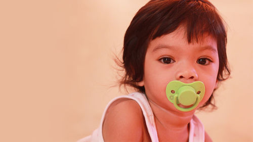 Portrait of cute girl carrying pacifier in mouth