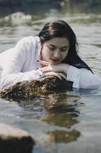 Portrait of young woman in lake