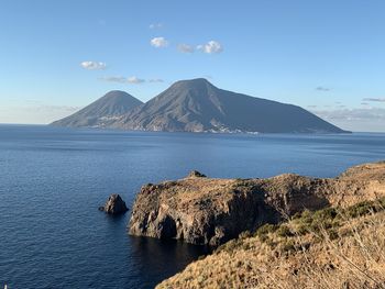 Scenic view of sea and mountains against sky