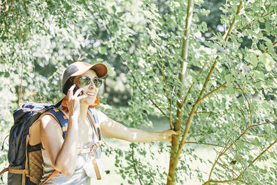 Woman wearing sunglasses against plants