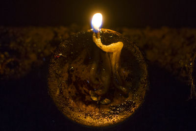 Close-up of illuminated light candle against black background