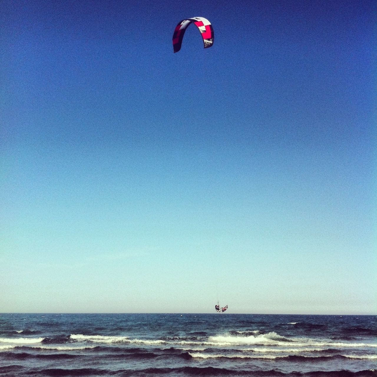 sea, water, leisure activity, clear sky, beach, horizon over water, extreme sports, lifestyles, blue, vacations, adventure, mid-air, copy space, parachute, sport, flying, enjoyment, scenics