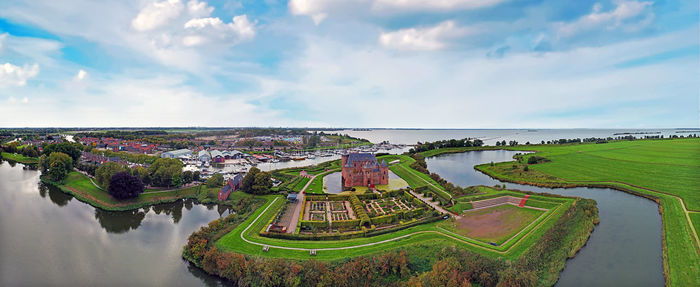 High angle view of cityscape by sea against sky