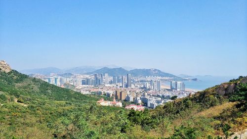 High angle view of cityscape against clear blue sky