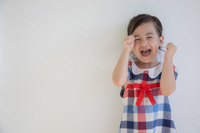 Cute girl standing against white background