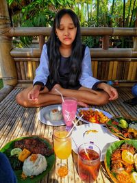 Full length of woman sitting on table