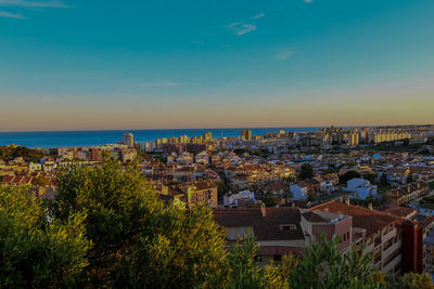 High angle view of townscape by sea against sky