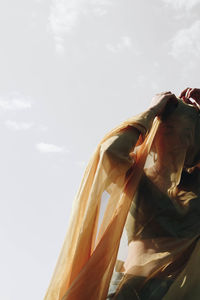 Low angle view of woman standing against sky