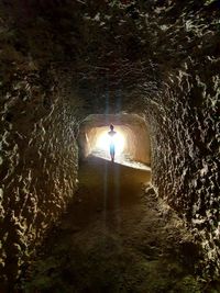 Man standing in illuminated tunnel