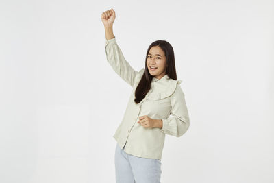 Portrait of smiling young woman against white background