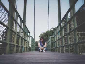 Portrait of woman sitting on bridge