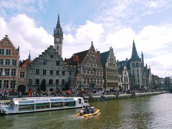 View of buildings at waterfront against cloudy sky