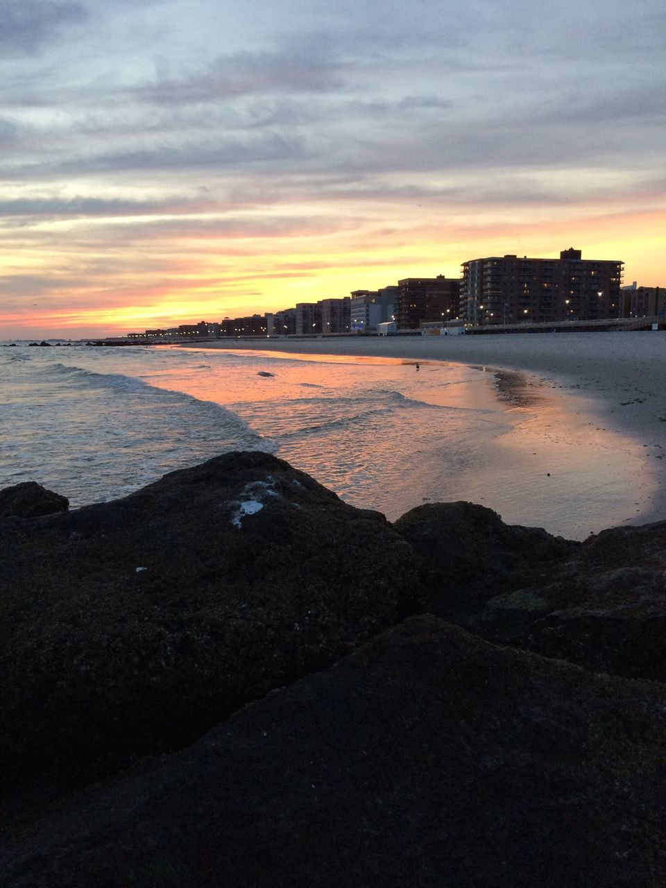 sunset, water, sea, sky, beach, building exterior, cloud - sky, built structure, shore, architecture, orange color, scenics, beauty in nature, horizon over water, tranquil scene, city, dusk, nature, tranquility, silhouette