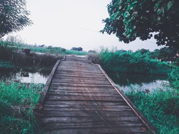 Wooden pier over lake against sky