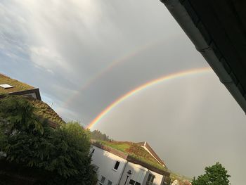 Rainbow over buildings against sky