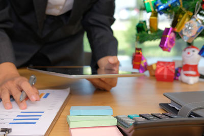 Midsection of businessman working on table during christmas