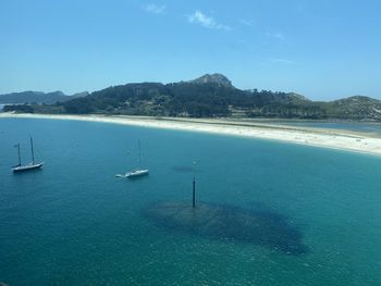 Sailboats in sea against blue sky