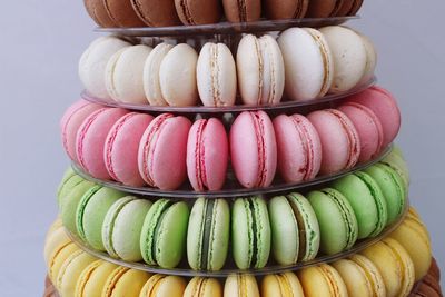 Close-up of multi colored macaroons on stand against wall