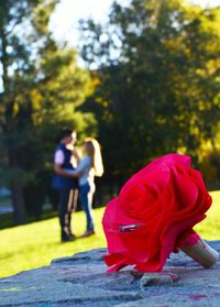 Rear view of couple walking with red umbrella