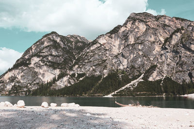 Scenic view of lake and mountains against cloudy sky