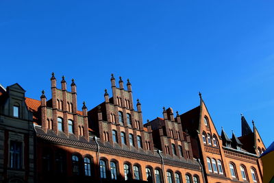 Low angle view of flags against clear blue sky