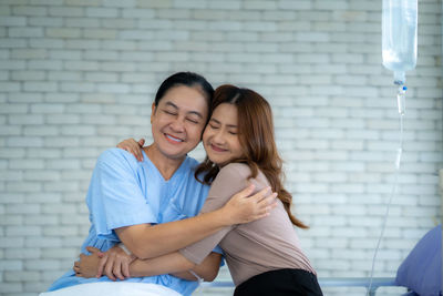 Portrait of smiling couple sitting on bed