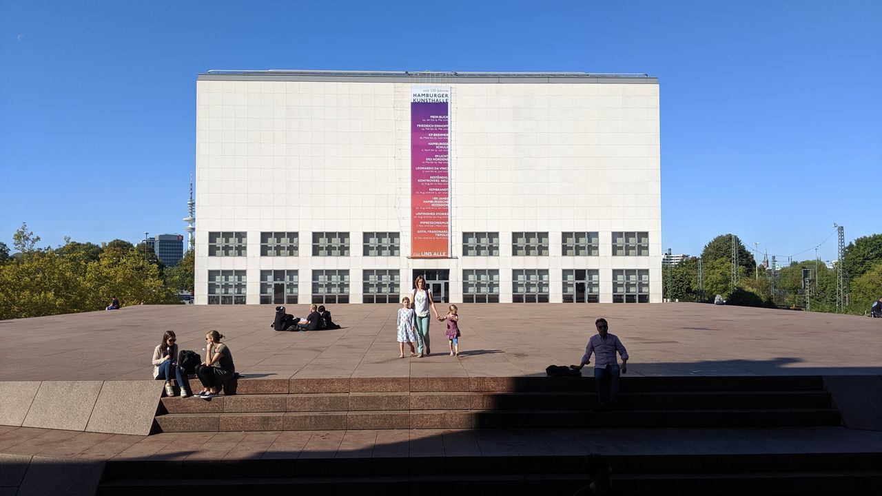 architecture, built structure, group of people, building exterior, real people, sky, women, men, clear sky, people, lifestyles, day, nature, city, blue, adult, sunlight, leisure activity, building, walking, outdoors