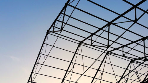 Low angle view of glass ceiling against clear blue sky