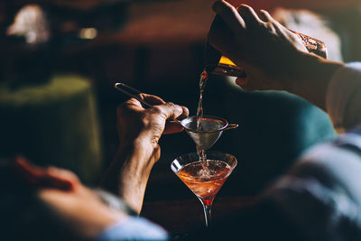 Cropped image of bartender preparing cocktail in bar