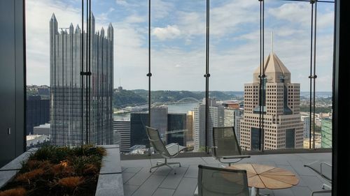 Modern buildings against sky seen through glass window