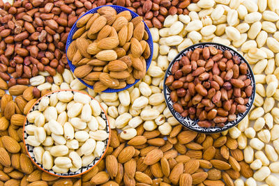 Almonds, peanut and hazelnuts in the bowl, beer and healthy snack, high angle view
