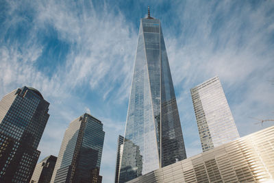 Low angle view of skyscrapers against cloudy sky