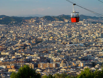 Cable car over cityscape against sky