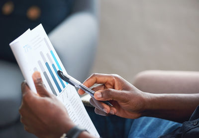 Midsection of man writing in book