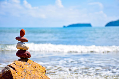 Close-up of rock in sea against sky