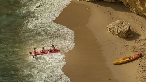 High angle view of father with children canoeing in sea