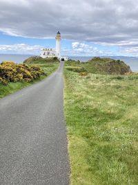 Road leading towards lighthouse against sky