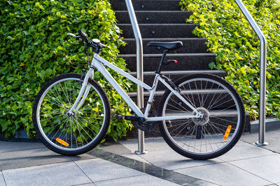 White urban bicycle parked in the street.