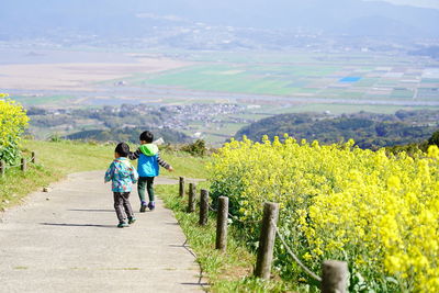 Rear view of boys walking on footpath