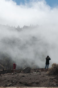 Man standing on mountain against sky